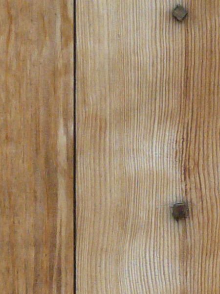 New wooden planks set vertically with bent nails.